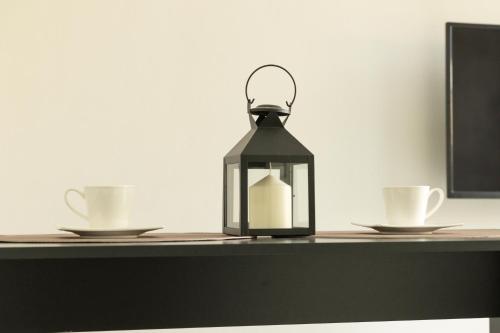 a lantern on a table with two cups at Alivio - Thuiskomen bij jezelf op vakantie in Lummen