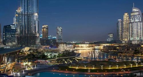 a night view of a city with tall buildings at Best View In Dubai With FULL Burj Khalifa, Fountains, Park View, Next to Dubai Mall and Opera in Dubai