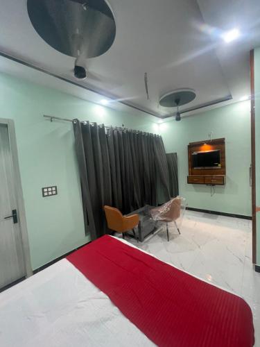 a living room with a red rug on the floor at VMP Villa Home Stay in Tājganj