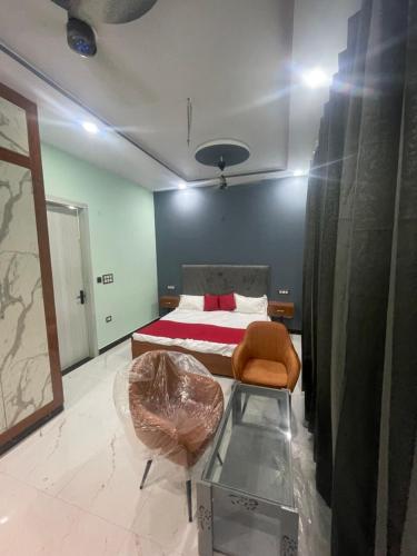 a bedroom with a bed and a chair and a table at VMP Villa Home Stay in Tājganj