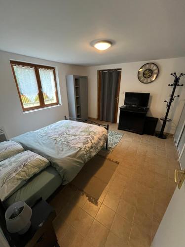 a bedroom with a bed and a clock on the wall at Logement paisible en bord de Vienne in Bonneuil-Matours