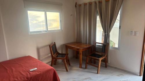 a bedroom with a table and two chairs and a bed at Estudio cerca del mar 2 in Puerto Morelos