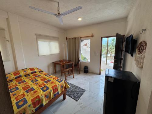 a bedroom with a bed and a table and a window at Estudio cerca del mar 2 in Puerto Morelos