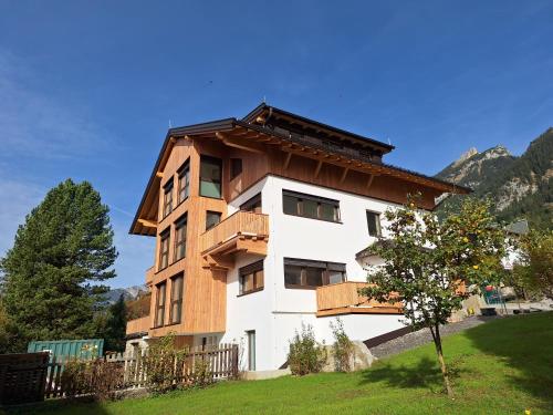 a house with a wooden roof on top of it at Landhaus Rofan in Maurach