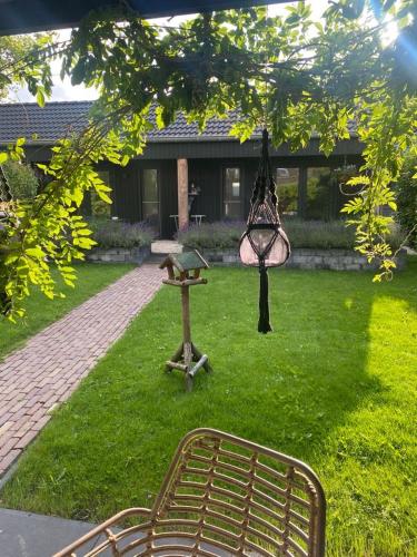 a park with a bench and a table and a lamp at De Burcht-Drenthe in Bunne