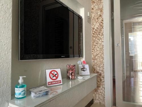 a bathroom with a shelf with a television on a wall at Suite Gravina + box auto privato in Gravina in Puglia