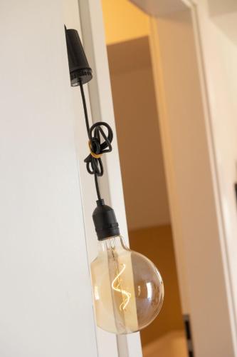 a glass light bulb hanging from a door at Alivio - Thuiskomen bij jezelf op vakantie in Lummen