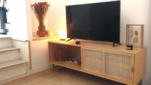 a flat screen tv sitting on top of a entertainment center at Escapade à Eymet in Eymet