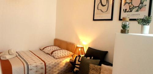 a small bedroom with a bed and a lamp at Escapade à Eymet in Eymet