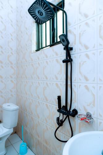 a bathroom with a blow dryer in front of a mirror at HIde Flowers Residence in Gasanze