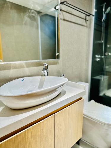 a bathroom with a white sink and a shower at Lazzlla Beachfront Oceanfront Apartments in Hulhumale