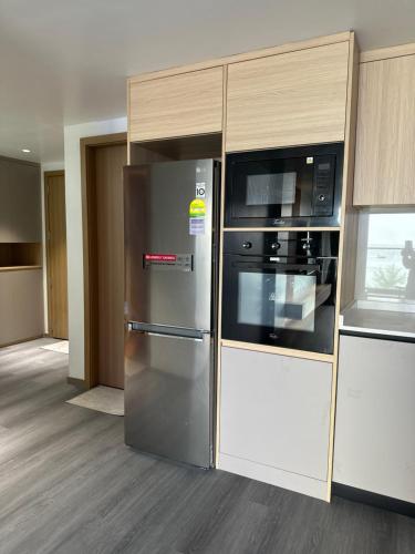 a kitchen with a stainless steel refrigerator and a microwave at Lazzlla Beachfront Oceanfront Apartments in Hulhumale