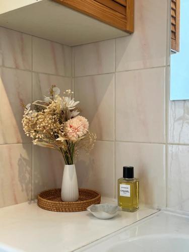 un vase de fleurs et une bouteille d'huile sur un évier dans l'établissement Un duplex de charme à Paris, à Paris