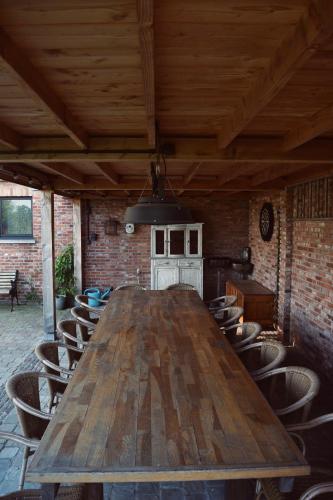 a large wooden table in a room with chairs at Vakantiewoning de Huismus in Oud-Turnhout