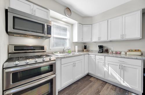 a kitchen with white cabinets and stainless steel appliances at Cozy Private Room in Hammond, IN - 2 in Hammond