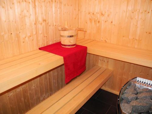 a inside of a sauna with a bucket on a red towel at Vechteperle - Nordhorn in Nordhorn