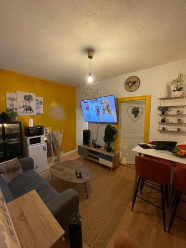 a living room with a couch and a table at Charmant appartement centre ville in Creil