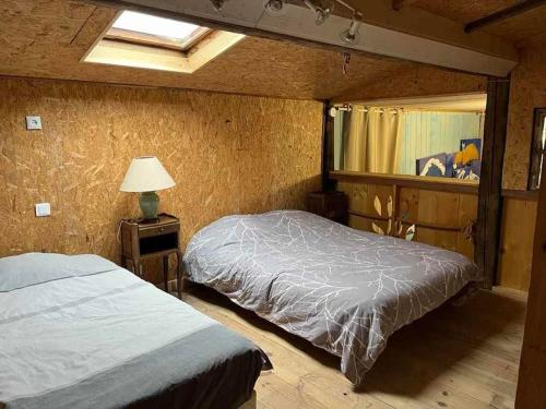 une chambre avec deux lits et une lampe et une fenêtre dans l'établissement Gîte le Saloon du Vermois, à Burthecourt-aux-Chênes