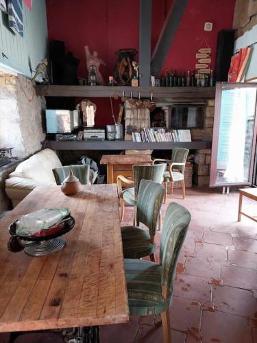 une grande table en bois et des chaises dans une pièce dans l'établissement Gîte le Saloon du Vermois, à Burthecourt-aux-Chênes