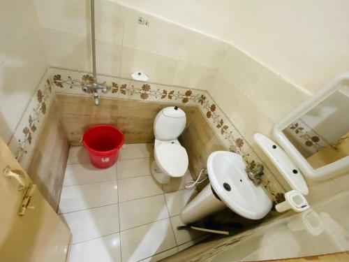 Un baño con un inodoro blanco y un lavabo. en Dream Inn 2, en Islamabad