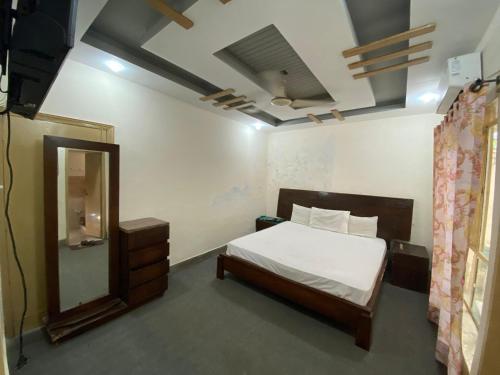 un dormitorio con una cama y un espejo en Dream Inn 2, en Islamabad