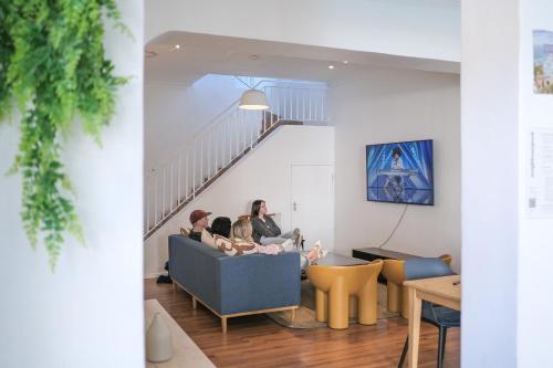 a group of people sitting on a couch in a living room at Neighbourgood Ravenscraig in Cape Town