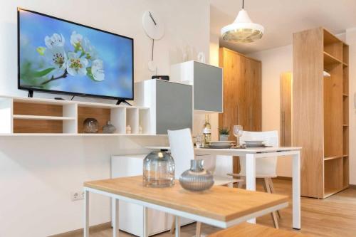 a living room with a table and a tv on a wall at NINO-Boardinghouse 18 in Nordhorn