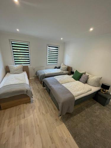 a room with three beds and two windows at Am Goethe Bogen in Zeuthen