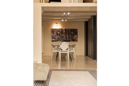 a dining room with two chairs and a painting on the wall at Fiorentini 22 - Suite Luxury con SPA in Matera