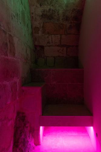 a staircase with pink lights in a room at Fiorentini 22 - Suite Luxury con SPA in Matera