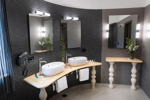 a bathroom with two sinks and two mirrors at Villa Caribe Resort & Spa in Spigno Saturnia