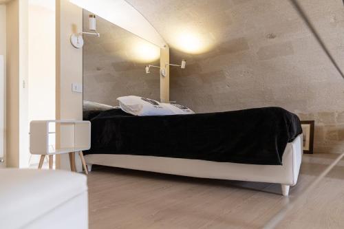 a room with a bed in front of a mirror at Fiorentini 22 - Suite Luxury con SPA in Matera