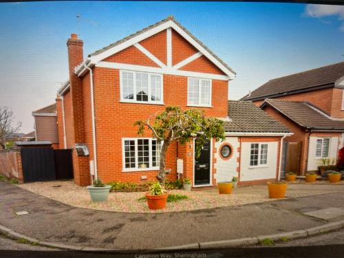 a red brick house with plants in front of it at SeaCross Sheringham Norfolk Coast 4beds, sleeps 7 in Sheringham
