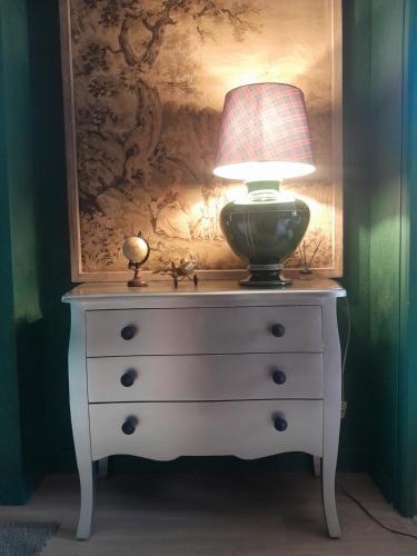 a lamp sitting on top of a dresser at Escapade en Alsace - gîte de charme pour deux à Bergheim in Bergheim