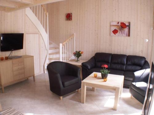 un soggiorno con un divano e una TV di Seebrise Baabe a Baabe