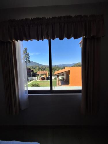 a window with a view of a house at Las casas de las flores in Ibarra