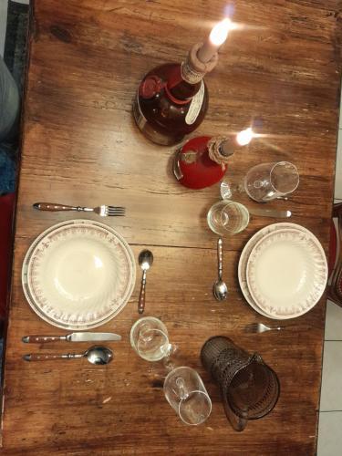 a wooden table topped with plates and wine glasses at Escapade en Alsace - gîte de charme pour deux à Bergheim in Bergheim