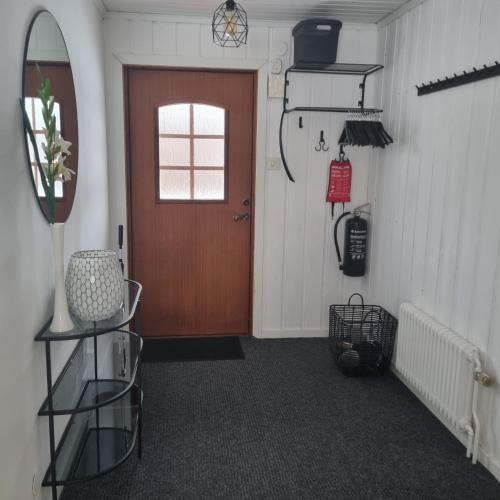 a hallway with a brown door and a window at Stuga i Kristdala in Kristdala