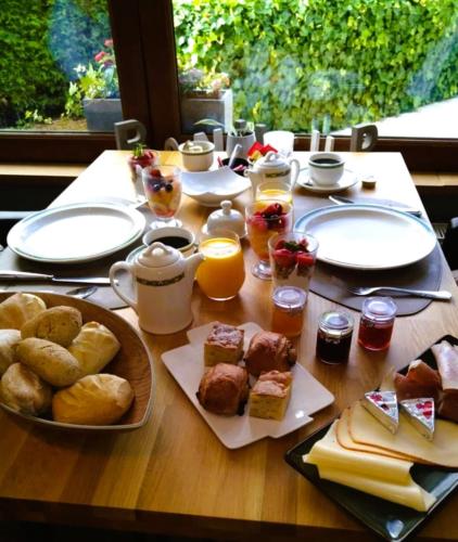 フロロンヴィルにあるHotel Au Coeur de Lacuisineの木製テーブル(朝食用の食材付)