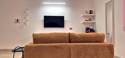 a brown couch in a living room with a tv at Casa Sunrise - The Guest House in Sciacca