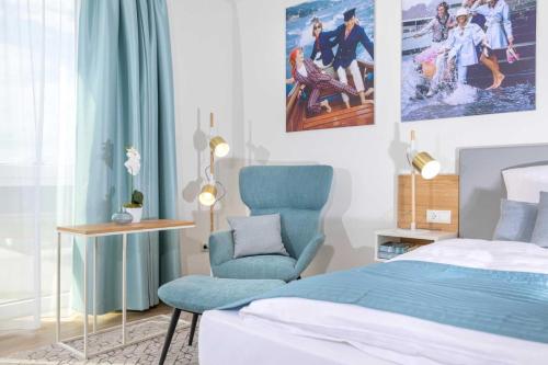 a bedroom with a bed and a blue chair at NINO-Boardinghouse 11 in Nordhorn