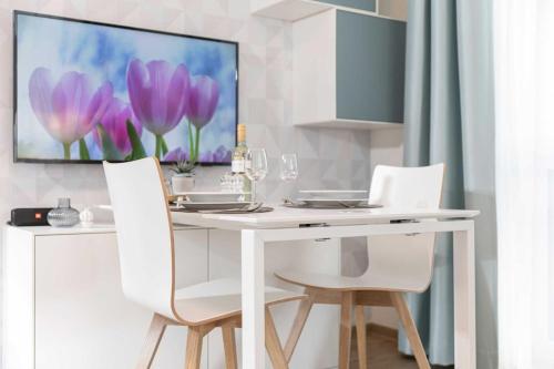 a white dining room table with two white chairs at NINO-Boardinghouse 6 in Nordhorn