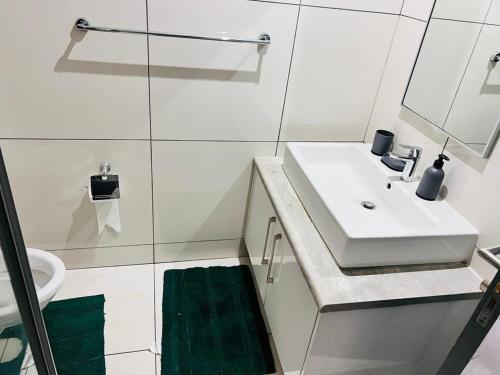 ウィントフークにあるShalom Apartment on independece 77 unit 102の洗面台と鏡のある白いバスルーム