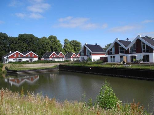 a row of houses next to a body of water at Ferienhaus Haus am See - Nordhorn in Nordhorn