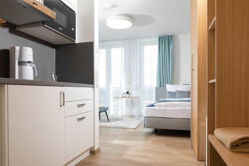 a room with a bedroom with a bed and a kitchen at NINO-Boardinghouse 6 in Nordhorn