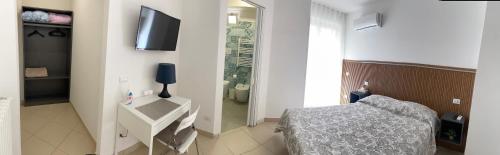 a bedroom with a bed and a television on a wall at La Casa di Annette in Fisciano