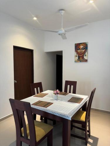 a dining room table with chairs and a painting on the wall at Family Friendly 3BR Apartment in Malabe, Colombo in Talahena