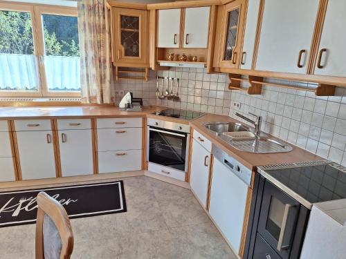 a kitchen with white cabinets and a sink at Steffi in Brixlegg