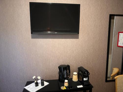 a flat screen tv hanging on a hotel room wall at Hotel Berthelot in Tours