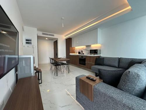 a living room with a couch and a kitchen at Grand Sapphire Luxury Residence By MyGuest Cyprus in Iskele